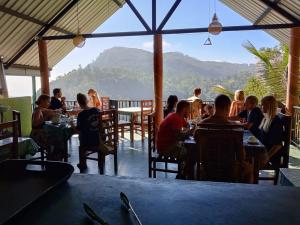 a group of people sitting at tables in a restaurant at New Ella Nature View in Ella