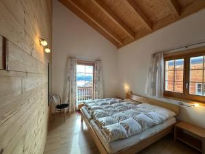 a large bed in a room with a window at Chalet Allegra AL0 in Belalp