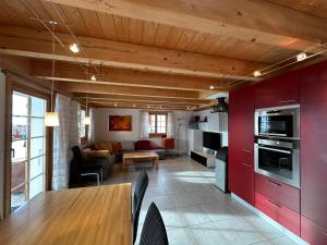 a kitchen and living room with red cabinets at Chalet Allegra AL0 in Belalp