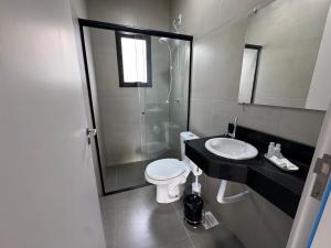 a bathroom with a shower and a toilet and a sink at Condomínio Noruega - casas 2 dormitórios in Jaguarão +38 photos