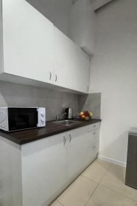 a kitchen with a sink and a microwave at Apartamenty Odrodzenia 11 in Szczytno +21 photos