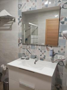 a bathroom with a white sink and a mirror at Casa Senderos del Norte in Sauzal