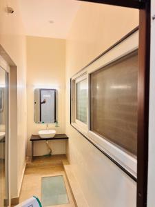 a bathroom with a sink and a window at Rajkamal Hampi in Hampi +10 photos