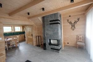 a living room with a stone fireplace in a house at Pikno Chata PL in Biały Dunajec