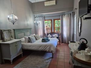 a bedroom with a bed and a table and a mirror at 12 On Milner in Kimberley