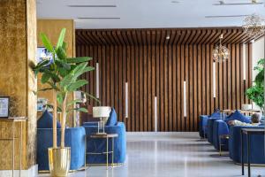 a lobby with blue chairs and a plant at Gorash Hotel in Khamis Mushayt