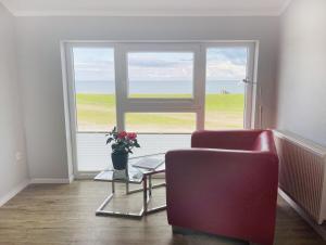 a living room with a chair and a window at Apartment Rickmer Rickmers Teichhof Fehmarn in Wenkendorf