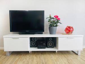 a white entertainment center with a tv and speakers at Apartment Rickmer Rickmers Teichhof Fehmarn in Wenkendorf
