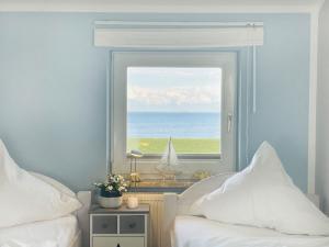 a bedroom with a window with a view of the ocean at Apartment Rickmer Rickmers Teichhof Fehmarn in Wenkendorf