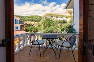 a balcony with two chairs and a table on a balcony at Pansion Nikos Vergos in Parga