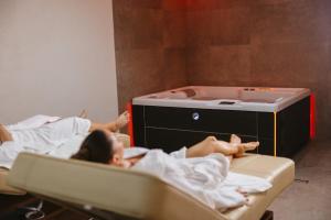 two children laying in beds in a room at Planet Gemini Residence & SPA in Niš