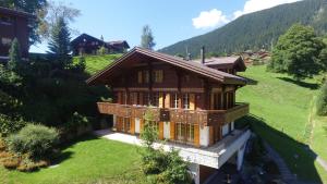 a small house on a hill with a green field at Chalet Rivendell - GRIWA RENT AG in Grindelwald