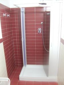 a shower with red tile in a bathroom at Casa Vacanze Helena in Cava dʼAliga