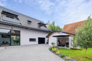 a white house with a courtyard and an umbrella at Zen et Chic in Hindisheim