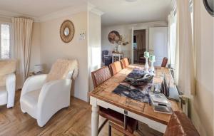 a dining room with a wooden table and white chairs at Nice Chalet In Putten in Putten