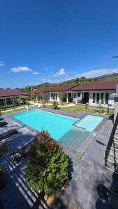 a large blue swimming pool in front of a building at Samati Hill - Pool Villa H2- Klong Ning Beach in Ko Lanta Yai