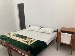 a bedroom with a bed and a nightstand and a bed sidx sidx at Valiyaveettile in Alwaye