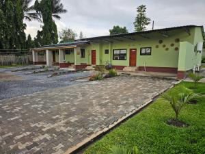 a green building with a stone path in front of it at Mew3 Apartment in Ndola