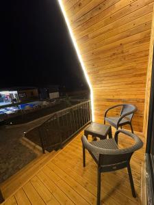 two chairs and a table on a wooden deck at night at Evergreen Lodge-2 in Çakırlar +2 photos