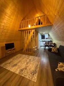 a living room with a wooden ceiling and a staircase at Evergreen Lodge-2 in Çakırlar