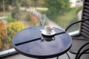 a table with a cup of coffee and a wine glass at Premium Planet Deluxe & SPA in Niš +74 photos