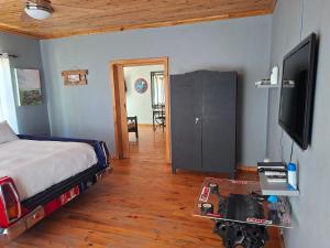 a bedroom with a bed and a flat screen tv at The V8 House in Sutherland