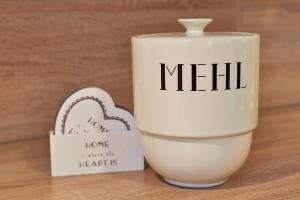 a mug with the word hell next to a heart at Südstern OG, Schwalbenweg in Wyk auf Föhr