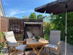 a patio with a table and two chairs and an umbrella at Südstern OG, Schwalbenweg in Wyk auf Föhr
