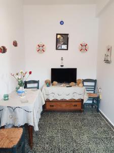 a room with two tables and a flat screen tv at Dimitreli Beach House in Telendos