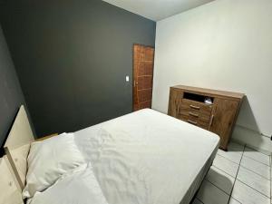 a small bedroom with a bed and a dresser at Casa no Centro in Corumbá