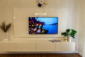 a living room with a tv on a wall at Premium Planet Deluxe & SPA in Niš