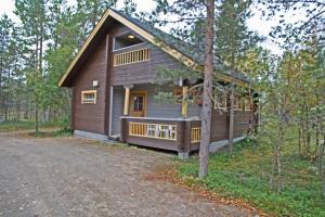 a cabin in the woods with a driveway at Ounasloma Holiday Cottages in Enontekiö