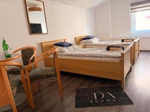 two beds in a room with a table and a chair at daroomz in Gloggnitz