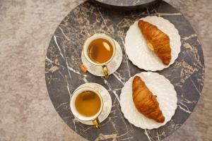 a glass table with two cups of tea and bread at Premium Planet Deluxe & SPA in Niš