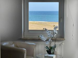 a window with a vase of flowers on a table at Apartment Potosi Teichhof Fehmarn in Wenkendorf