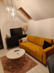 a living room with a yellow couch and a table at Pienińskie Zacisze in Jaworki