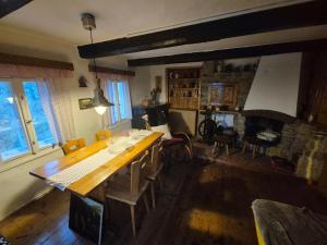 a dining room with a table and a fireplace at Roubenka Vendryně in Vendryně