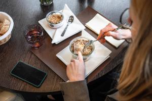 a woman sitting at a table with a bowl of food at Kyriad Rennes Nord Hotel in Rennes