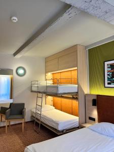 a room with two bunk beds and a chair at Qubus Hotel Wrocław in Wrocław +107 photos