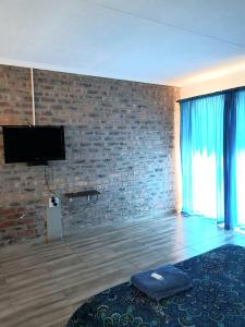 a room with a brick wall and a flat screen tv at Bredell Motel in Bredell