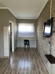a dining room with a black chair and a window at Bredell Motel in Bredell +9 photos