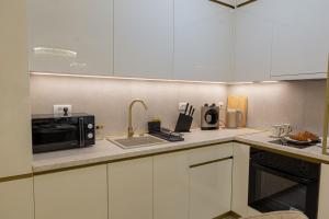 a kitchen with a sink and a microwave at Premium Planet Deluxe & SPA in Niš