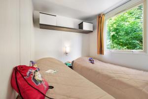 a room with two beds and a red bag at Vakantiepark het Wieskamp in Henxel +94 photos