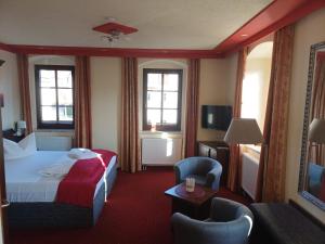 a hotel room with a bed and a tv at Landhotel Thürmchen in Schirgiswalde +28 photos
