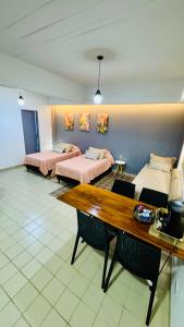 a room with two beds and a wooden table at Monoambiente Eldorado 1 in Eldorado
