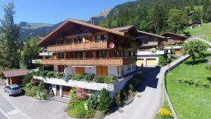 a large building with plants on the side of a road at Apartment Alpenblume - GRIWA RENT AG in Grindelwald