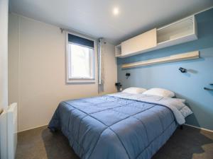 a bedroom with a bed with blue walls and a window at Camping A la Corniche - Maeva in Angoulins-sur-Mer +32 photos