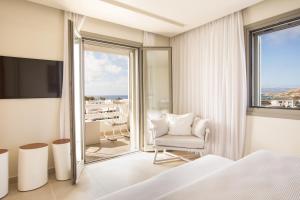 a bedroom with a bed and a room with a balcony at 18 Grapes Hotel in Agios Prokopios