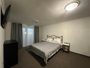 a hotel room with a bed and a window at Grey House in Kvasy