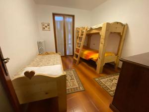 a room with two bunk beds and two rugs at Dormire a Valgoglio Baita della Diga in Valgoglio